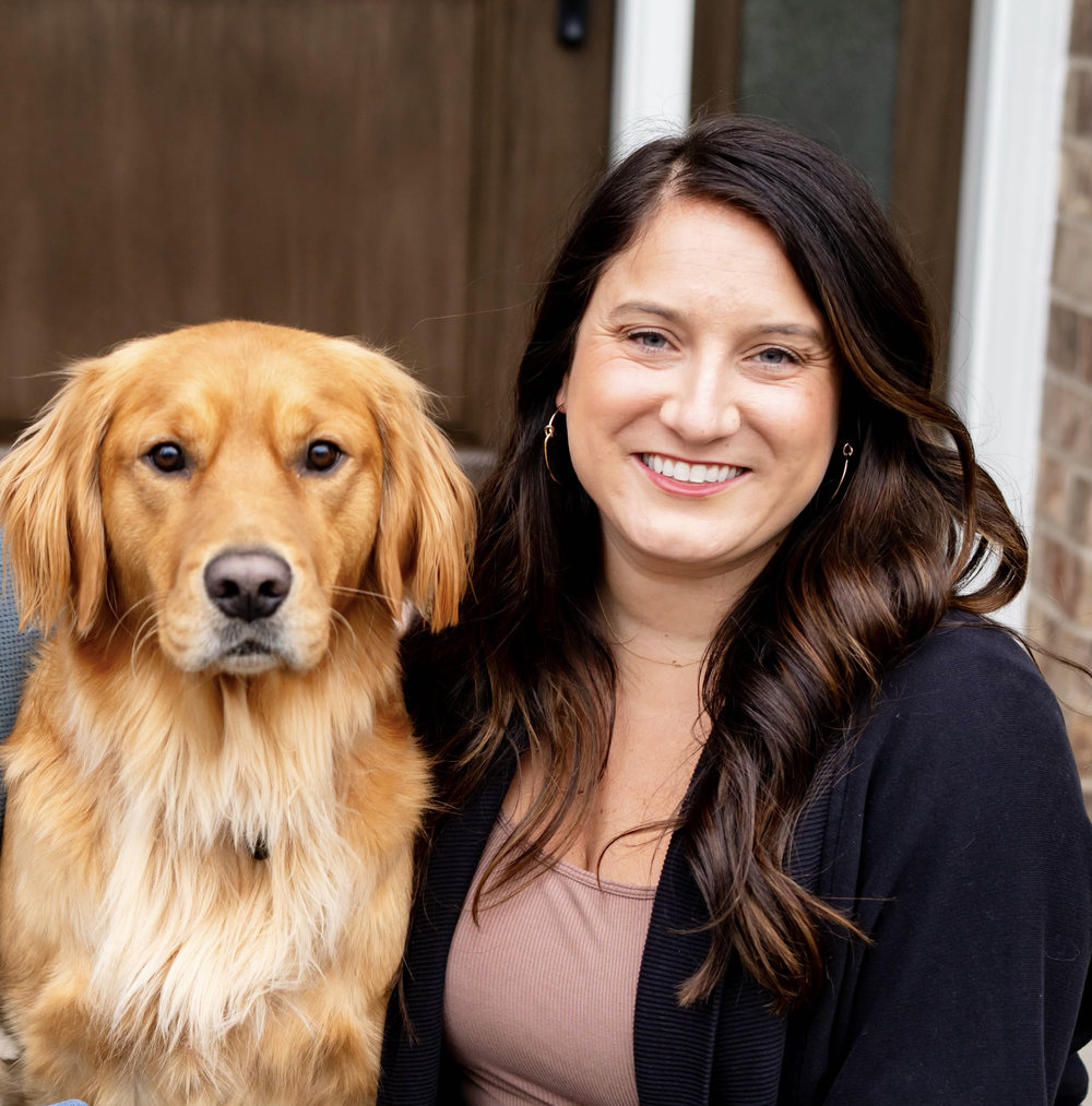 Vanessa, the owner of LinkyHoop, smiling beside Linky, a golden retriever, outdoors in front of a door.